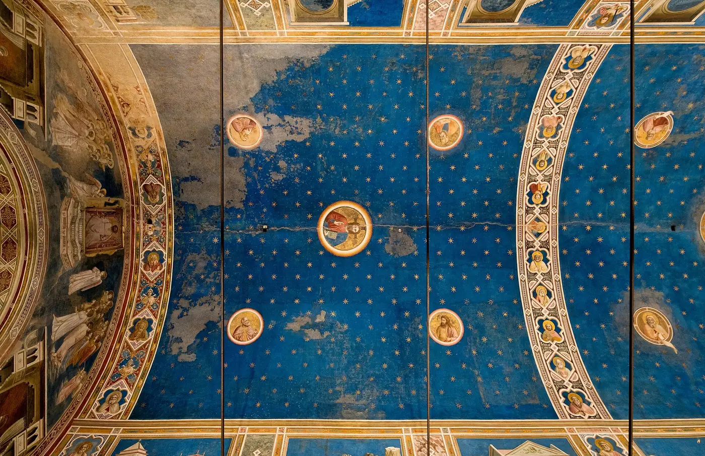 Giottos Tonnengewölbe in der Scrovegni-Kapelle, tiefblau mit goldenen achtzackigen Sternen und gemalten Rundmedaillons von Christus, der Madonna und den Propheten